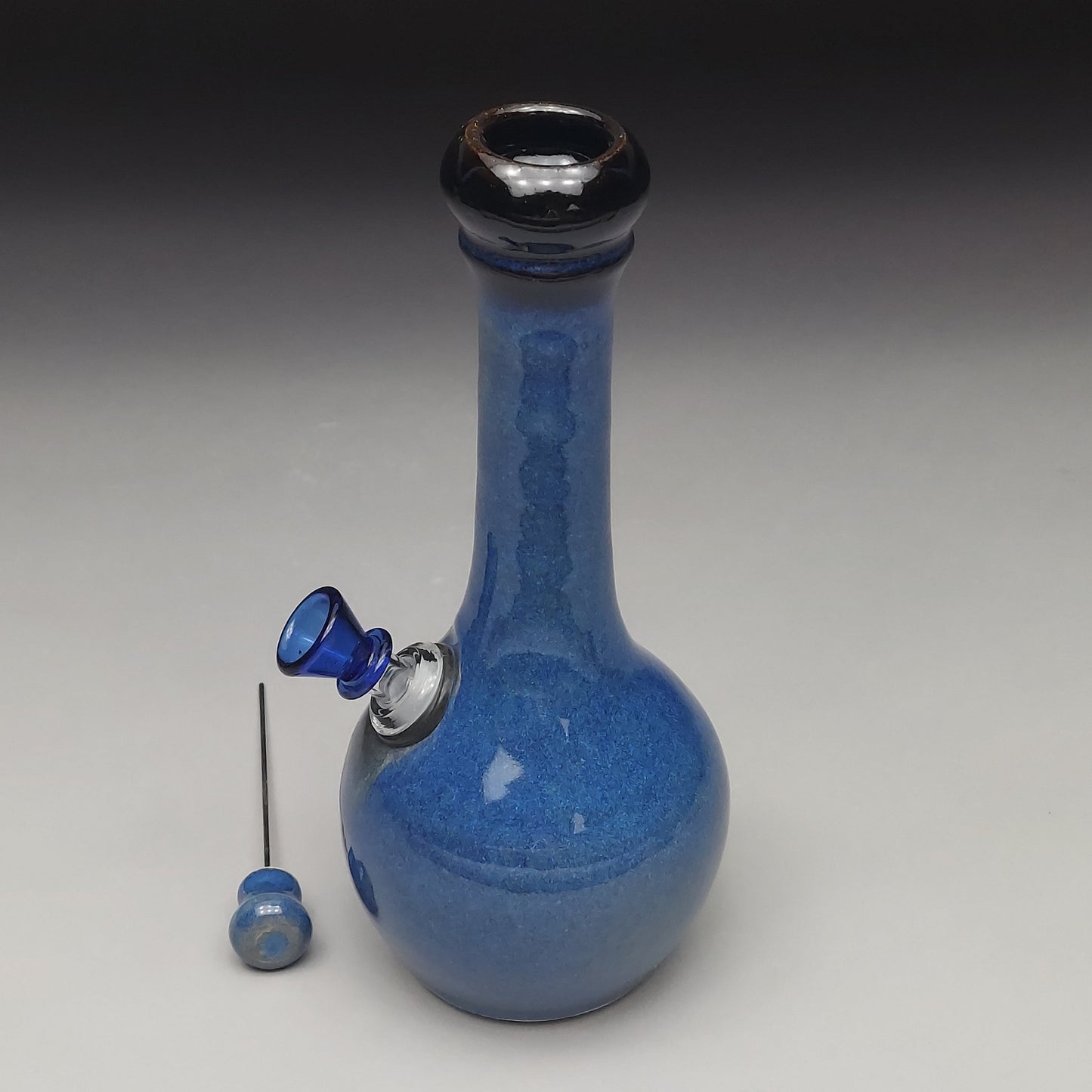 Blue ceramic water pipe with accessories on a gray background