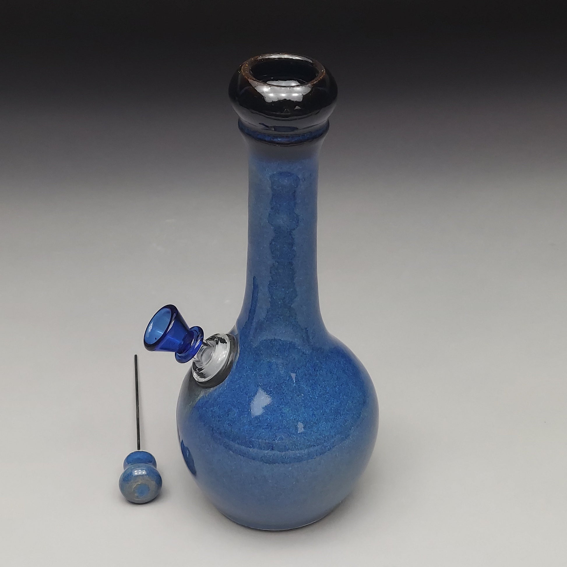 Blue ceramic water pipe with accessories on a gray background